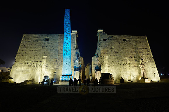 night shot of illuminated statues and obelisk of Ramesses II.