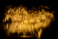 water reflection of illuminated Lycian rock tombs in a rock face of Dalyan