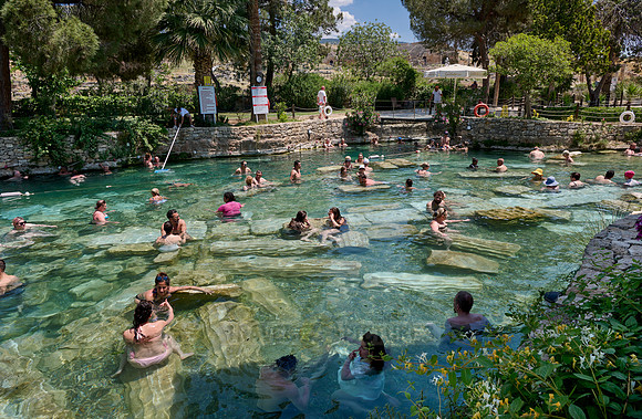 people swimming in natural swimming pool with columns in Greek Hierapolis