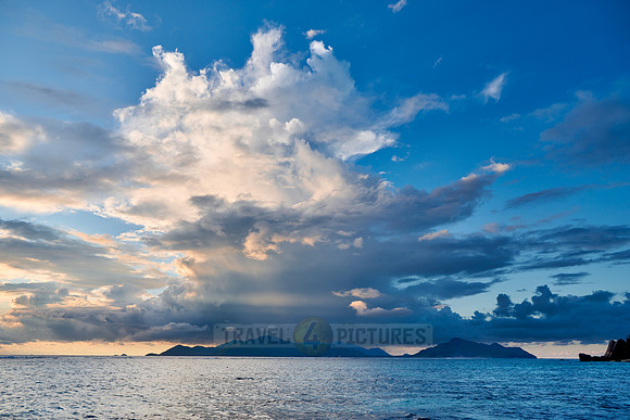 Cloud towers over Praslin in the evening seen from Anse Source D'Argent