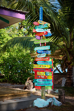 colorful information signs with distances to places around the world on La Digue