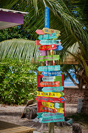 colorful information signs with distances to places around the world on La Digue