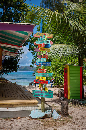 colorful information signs with distances to places around the world on La Digue