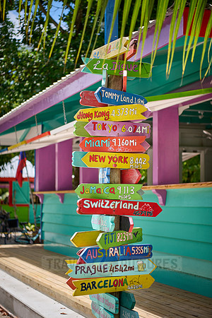 colorful information signs with distances to places around the world on La Digue