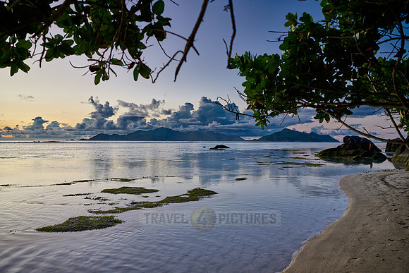 characteristic rock formation with colorful clouds on the beach of Anse Source D'Argent