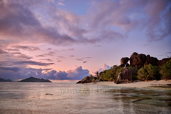 characteristic rock formation with colorful clouds on the beach of Anse Source D'Argent