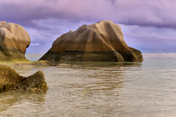 characteristic rock formation with colorful clouds on the beach of Anse Source D'Argent