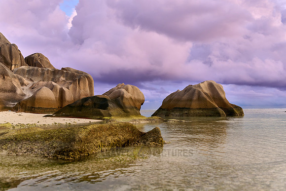 characteristic rock formation with colorful clouds on the beach of Anse Source D'Argent