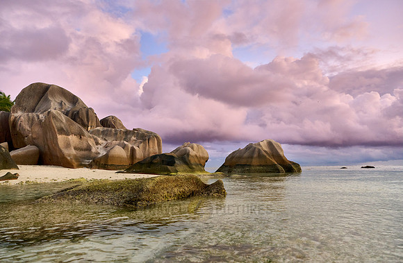 characteristic rock formation with colorful clouds on the beach of Anse Source D'Argent
