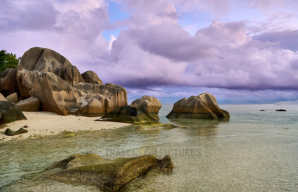 characteristic rock formation with colorful clouds on the beach of Anse Source D'Argent