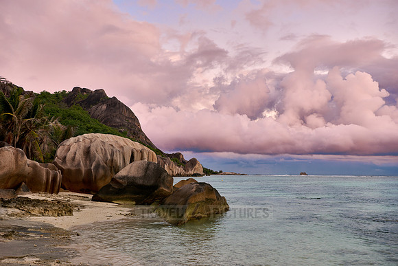 characteristic rock formation with colorful clouds on the beach of Anse Source D'Argent