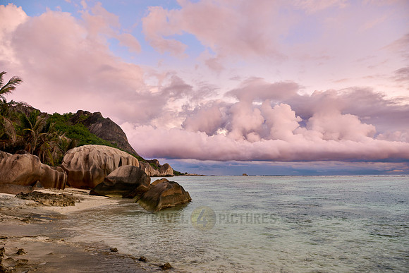 characteristic rock formation with colorful clouds on the beach of Anse Source D'Argent