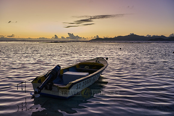 small boats during sunset on sea of La Digue