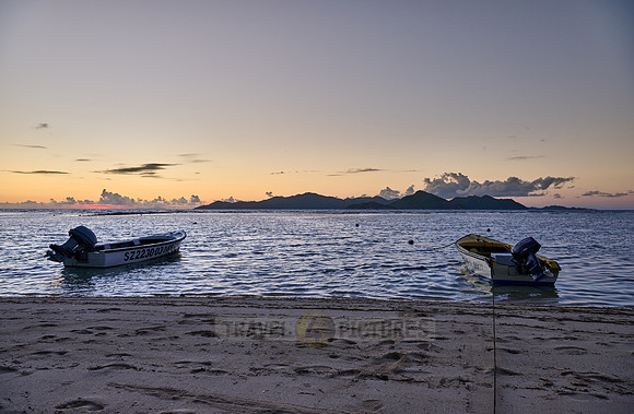 small boats during sunset on sea of La Digue