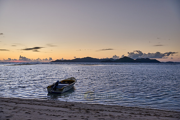 small boats during sunset on sea of La Digue