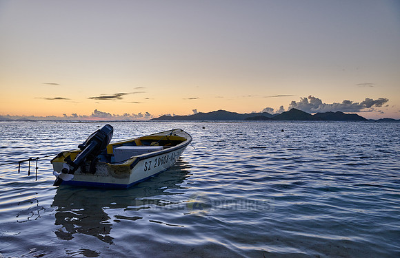 small boats during sunset on sea of La Digue