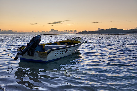 small boats during sunset on sea of La Digue