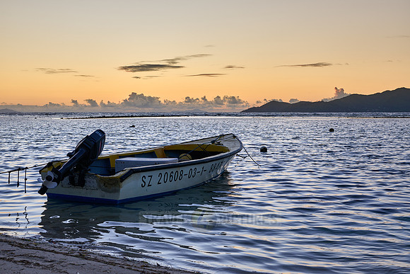 small boats during sunset on sea of La Digue