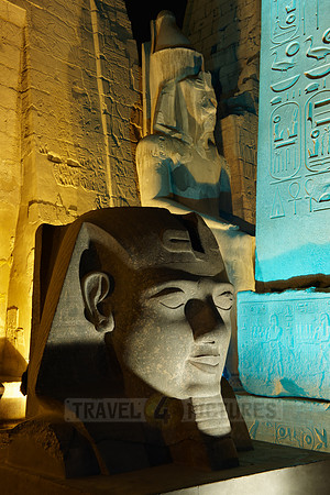 night shot of illuminated statues and obelisk of Ramesses II. in front of first Pylon