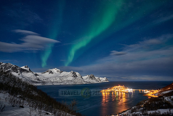 Aurora Borealis over winter landscape in fjord of Husøy
