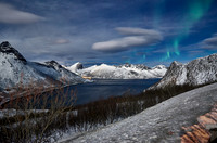 Aurora Borealis over winter landscape in fjord of Husøy