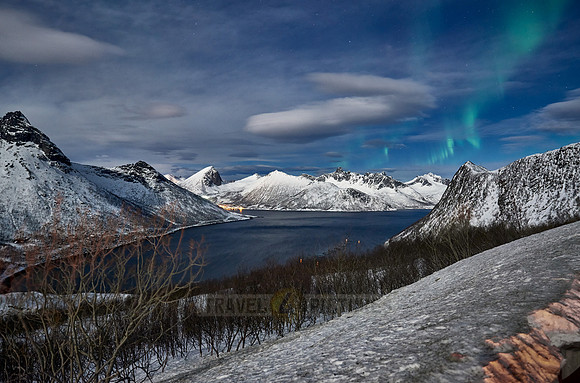 Aurora Borealis over winter landscape in fjord of Husøy