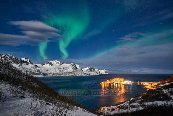 Aurora Borealis over winter landscape in fjord of Husøy
