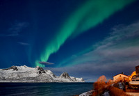 Aurora Borealis over winter landscape in fjord of Husøy