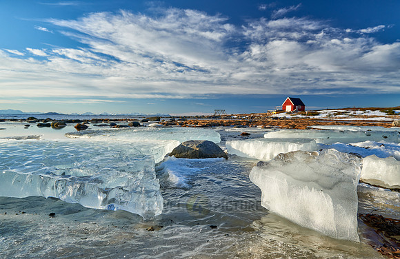 winter landscape with ice floes and typical red house
