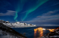 Aurora Borealis over winter landscape in fjord of Husøy