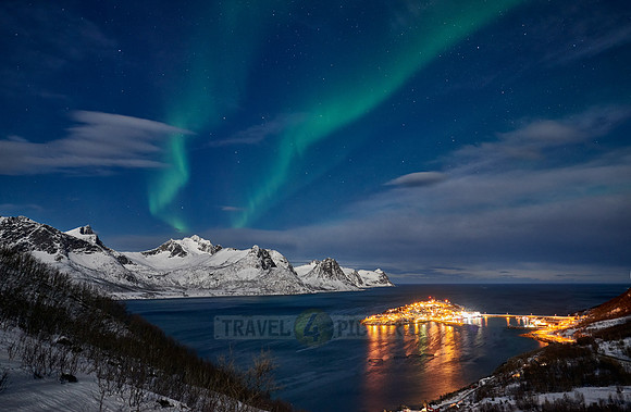Aurora Borealis over winter landscape in fjord of Husøy