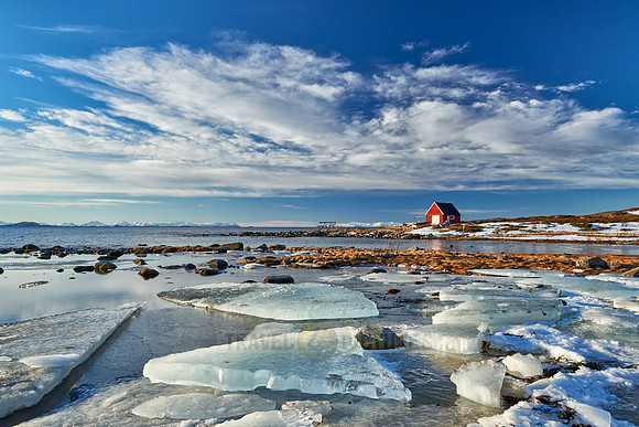 winter landscape with ice floes and typical red house