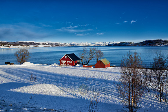 winter landscape with typical red house in Senja
