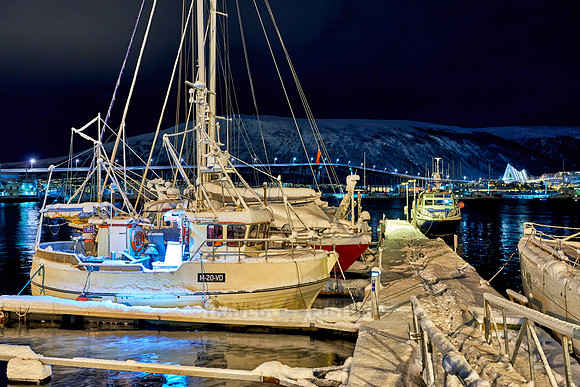 night shot of a snow covered vessel in harbour of Tromsø
