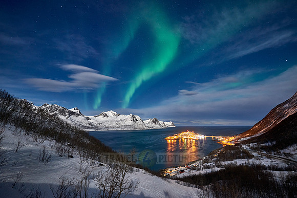 Aurora Borealis over winter landscape in fjord of Husøy