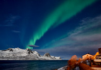 Aurora Borealis over winter landscape in fjord of Husøy