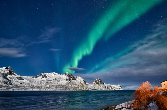 Aurora Borealis over winter landscape in fjord of Husøy