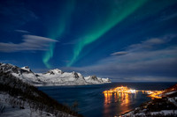Aurora Borealis over winter landscape in fjord of Husøy