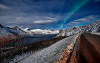 Aurora Borealis over winter landscape in fjord of Husøy
