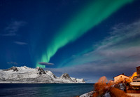 Aurora Borealis over winter landscape in fjord of Husøy