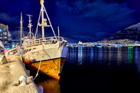 night shot of a snow covered vessel in harbor of Tromsø