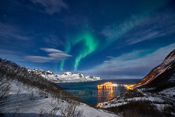 Aurora Borealis over winter landscape in fjord of Husøy
