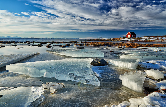 winter landscape with ice floes and typical red house
