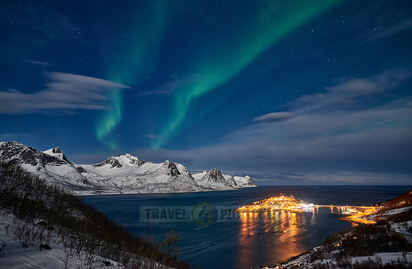 Aurora Borealis over winter landscape in fjord of Husøy