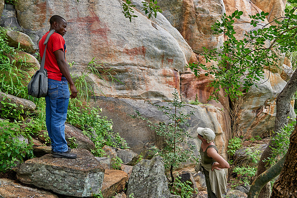tourist and guide looking on Rock art