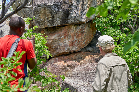 tourist and guide looking on Rock art
