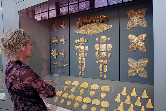 Visitor in front of a showcase with gold jewelry