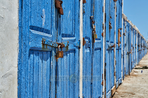locked wooden blue doors in row from fishery equipment sheds