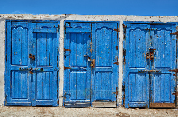 locked wooden blue doors in row from fishery equipment sheds