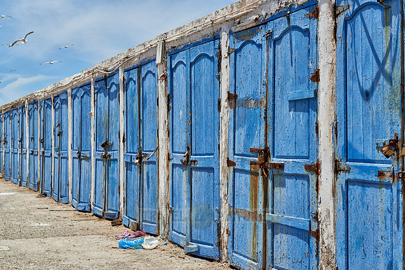 locked wooden blue doors in row from fishery equipment sheds